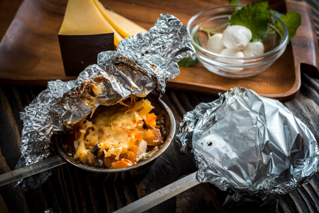 Air fryer basket lined with aluminum foil ready for cooking