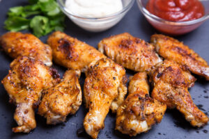 Air fryer cooking chicken wings, capturing the appliance in action with wings inside.