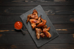 appetizing chicken wings grilled barbecue with spices and vegetables until crisp