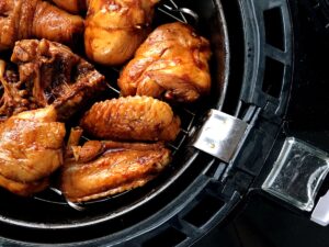 Frozen chicken breasts being cooked in an air fryer, showcasing the no-thaw convenience for quick and healthy meals.