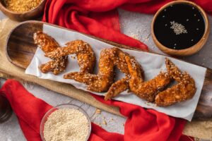 Frozen chicken wings being cooked in an air fryer, capturing the wings midway through the cooking process.